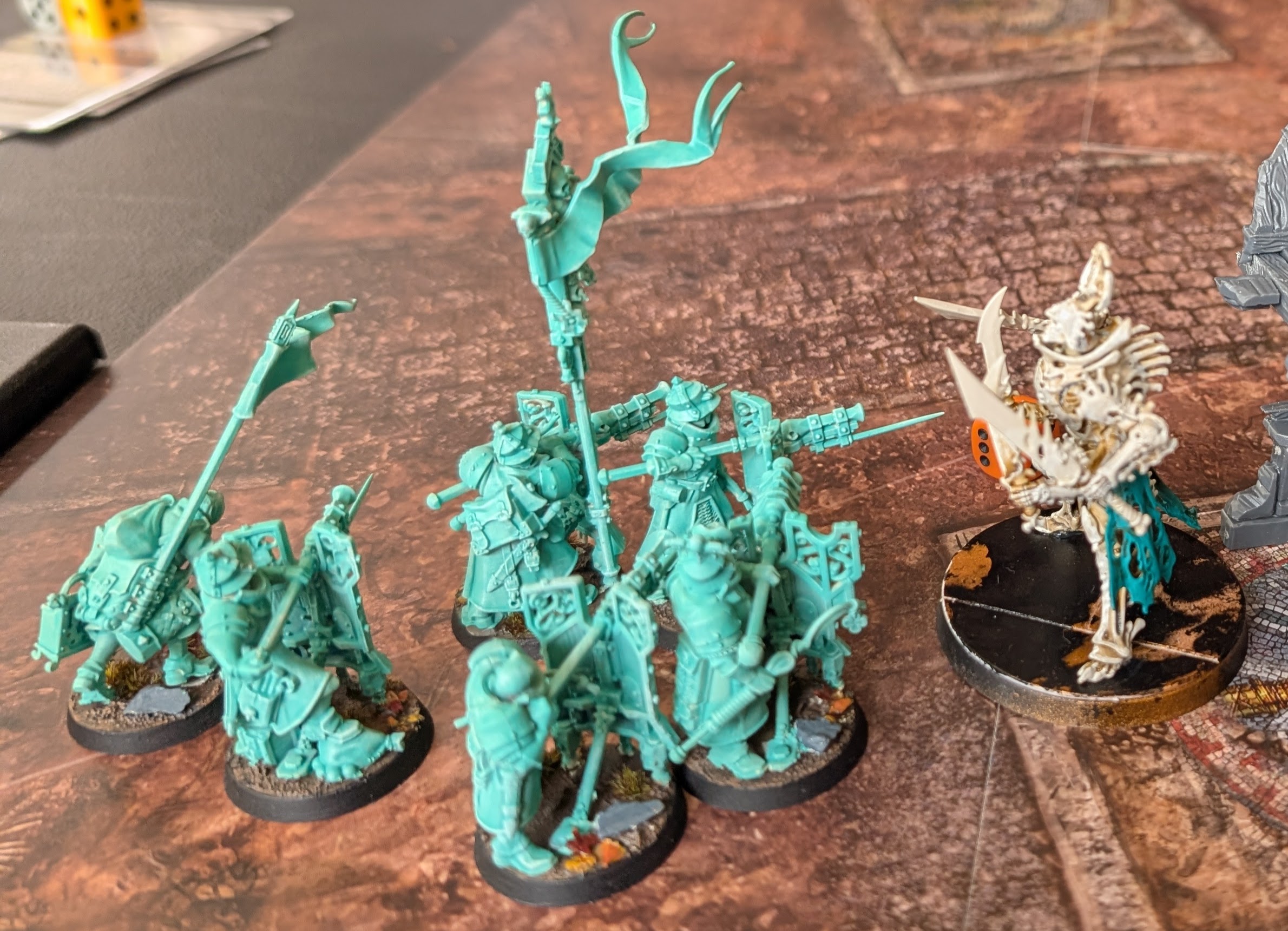 Ghostly turquoise Cities of Sigmar fusiliers face a bone-white Necropolis Stalker.